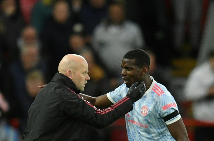Paul Pogba avec l'entraîneur adjoint de Manchester United Mike Phelan en Premier League sur la pelouse de Liverpool le 19 avril 2022