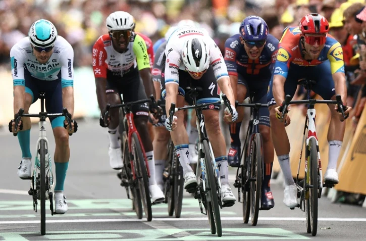 Le Belge Tim Merlier, en blanc au centre, remporte le sprint massif à l'arrivée de la 3e étape du Tour de France, le 7 juillet 2025 à Dunkerque