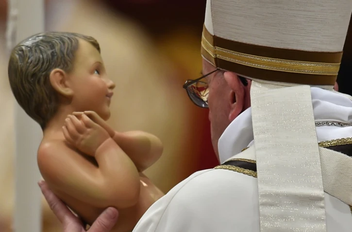 Le pape François tient une statué de Jésus bébé durant la messe de Noël, le 24 décembre 2015 à la basilique Saint Pierre de Rome