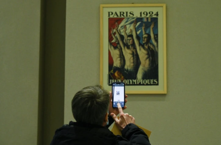 Un journaliste utilise son portable pour prendre une photo dans un bâtiment des JO à Zhangjiakou, en Chine, le 21 décembre 2021