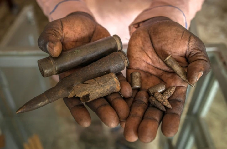 Un homme montre des balles exposées au Mémorial de Lukodi, souvenir du'un massacre perpétré dans ce village du nord de l'Ouganda en mai 2004 par la guérilla ougandaise de l'Armée de résistance du Seigneur (LRA), le 4 septembre 2025