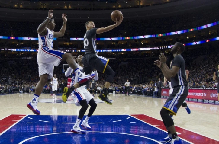 Le joueur des Golden State Warriors Stephen Curry (c) marque un panier contre face aux Philadelphia 76ers Ă Philadelphie, le 30 janvier 2016