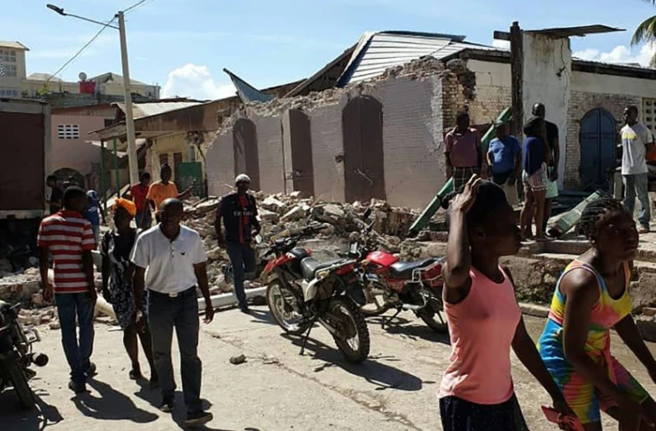 Des habitants regardent les maisons effondrés dans la ville de Jérémie après le séisme qui a frappé le sud-ouest d'Haïti, le 14 août 2021 