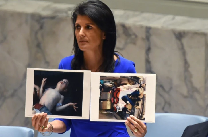 L'ambassadrice US aux Nations Unies, Nikki Haley, montre des photos de victimes lors d'une session au Conseil de sécurité de l'ONU le 5 avril 2017 évoquant une attaque chimique du régime du président syrien Bachar al-Assad tuant des civils en Syrie