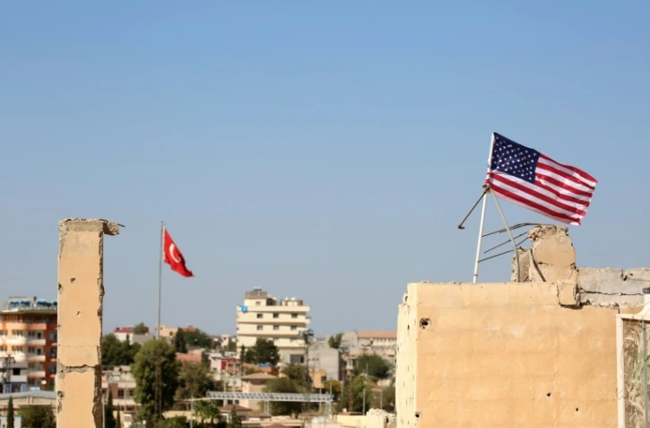 Des drapeaux turc (G) et américain (D) flottent le 17 septembre 2016 au-dessus du village syrien de Tal Abyad, à l'extrême nord du pays près de la frontière turque
