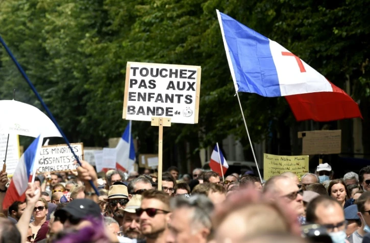 Un manifestant tient une banderole sur laquelle on peut lire "Ne touchez pas aux enfants" lors d'une journée nationale de protestation contre le vaccin obligatoire contre le Covid-19 pour certains travailleurs et l'utilisation obligatoire du pass sanitaire à Lille, dans le nord de la France, le 21 août 2021