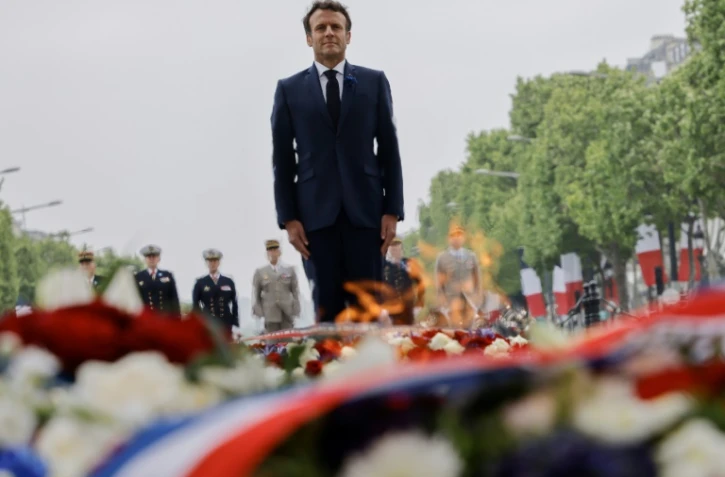 Le président Emmanuel Macron dépose une gerbe de fleurs sur la tombe du soldat inconnu à l'Arc de Triomphe, à Paris le 8 mai 2022
