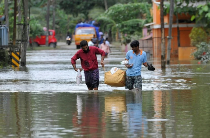 Des Indiens transportent de la nourriture et de l'eau pour les déplacés des inondations, dans le district d'Alappuzha, dans l'état indien du Kerala, le 21 août 2018