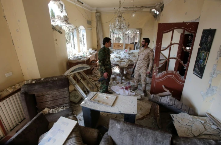 Les forces gouvernementales syriennes inspectent une maison détruite lors des affrontements à Daraya, au sud-ouest de la capitale syrienne Damas le 24 février 2016