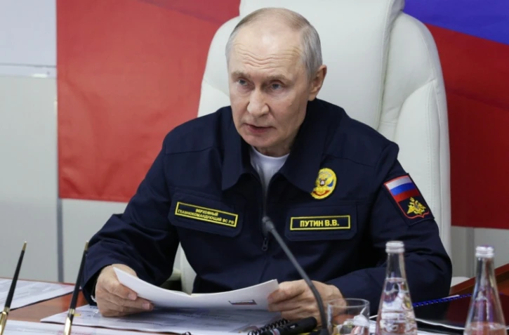 Photo diffusée par l'agence d'État russe Sputnik montrant le président russe Vladimir Poutine à bord du croiseur lance-missiles Varyag de la Marine russe, lors de la phase finale des exercices navals de la Flotte du Pacifique, sur l'île de Sakhaline, à l'Extrême-Orient, le 12 août 2026