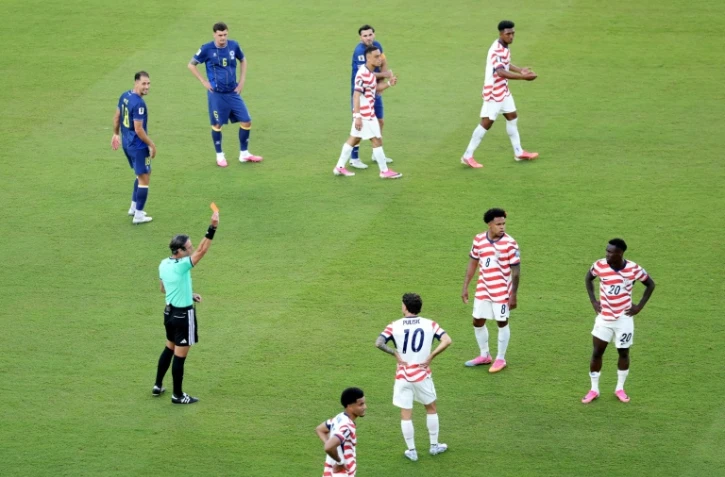 L'attaquant américain Folarin Balogun (à droite) expulsé par l'arbitre Raphael Claus pour une faute sur le Bosnien Tarik Muharemovic en 16e de finale de la Coupe du monde le 1er juillet 2026 à Santa Clara, près de San Francisco