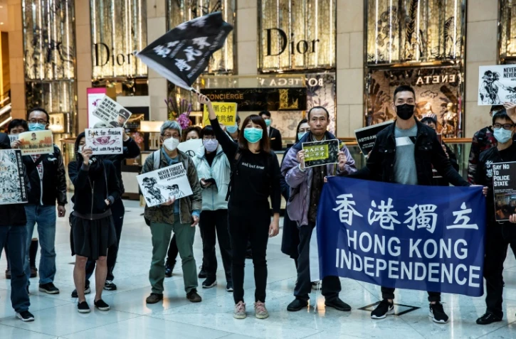 Employés et manifestants sont rassemblés devant un centre commercial pour réclamer plus de démocratie à Hong Kong, le 21 février 2020