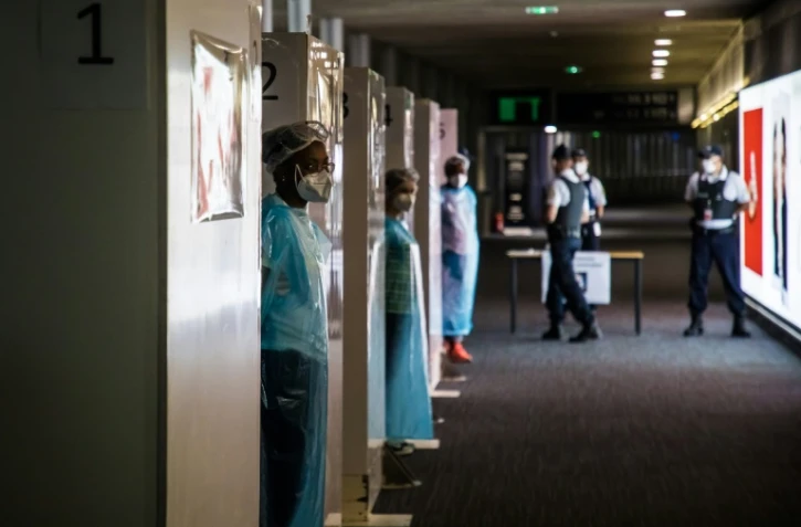 Des soignants attendent l'arrivée de voyageurs au sein d'une unité de tests Covid-19, à l'aéroport Roissy-Charles de Gaulle à Paris, le 24 juillet 2020