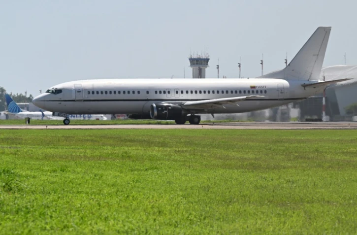 Un avion transportant des migrants vénézuéliens emprisonnés au Salvador sur le tarmac de l'aéroport international San Oscar Romero avant de décoller pour le Venezuela, le 18 juillet 2025 à San Luis Talpa, au Salvador