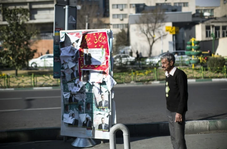 Un homme se tient à côté d'affiches électorales à Téhéran, capitale de l'Iran, le 25 février 2016 