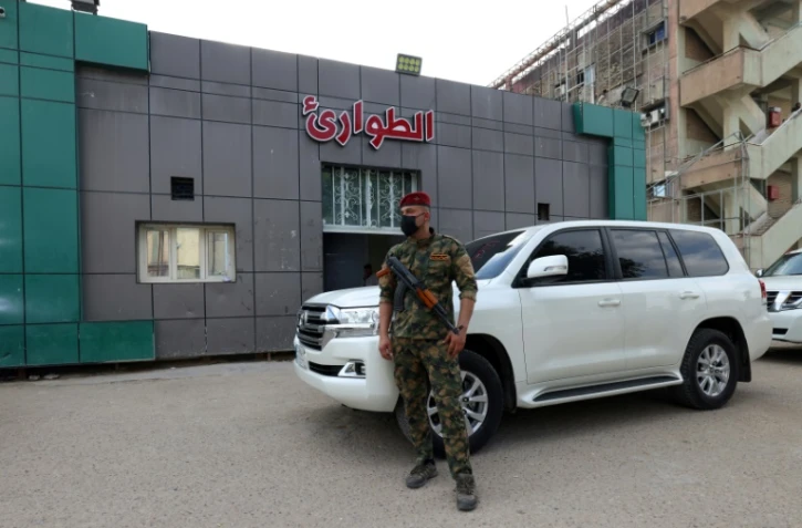 Un soldat posté devant l'entrée des urgences d'un hôpital de Hilla, où sont soignées des personnes blessées dans une explosion nocturne sur une base militaire en Irak, le 20 avril 2024