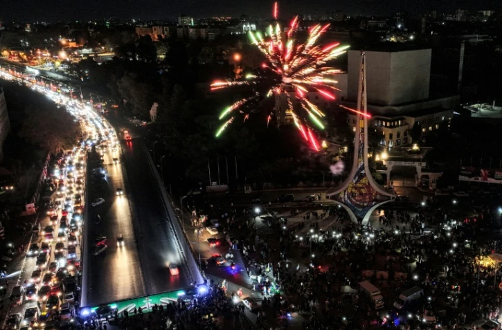 Vue aérienne de feux d'artifice et de la foule de Syriens célébrant le renversement du président Bachar al-Assad, sur la place des Omeyyades à Damas, le 13 décembre 2024