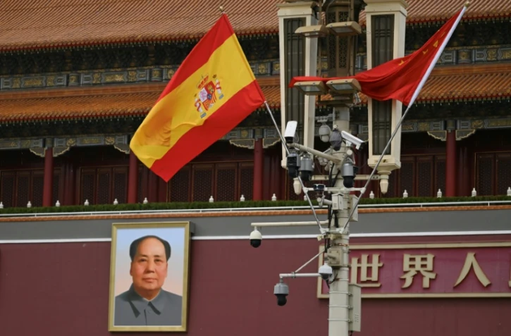 Le drapeau espagnol flotte devant le portrait de l'ancien dirigeant communiste chinois Mao Zedong à  Tiananmen à l'occasion de la visite du Premier ministre espagnol Pedro Sanchez à Pékin, le 13 avril 2026