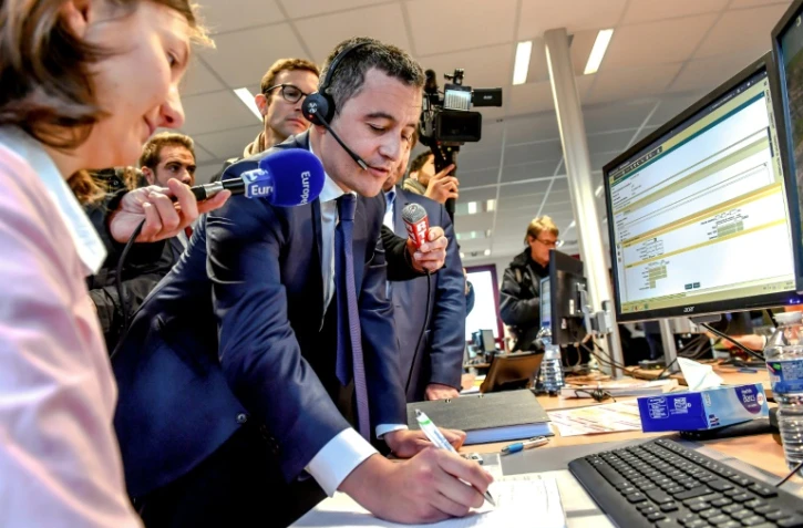 Le ministre des Comptes publics Gérald Darmanin parle avec un contribuable au téléphone depuis le centre des impôts d'Amiens, le 2 janvier 2019
