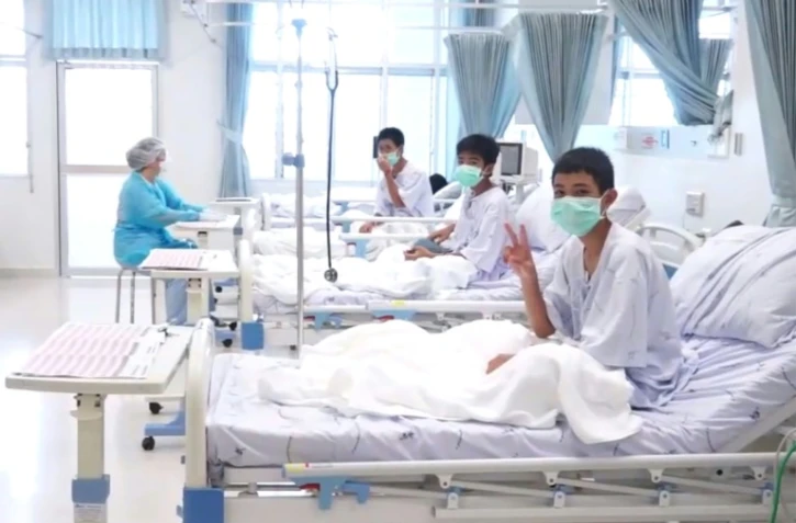 Capture d'écran d'une vidéo fournie par le gouvernement thaïlandais montrant des jeunes footballeurs hospitalisés à Chiang Rai après leur évacuation d'une grotte où ils étaient restés bloqués 18 jours