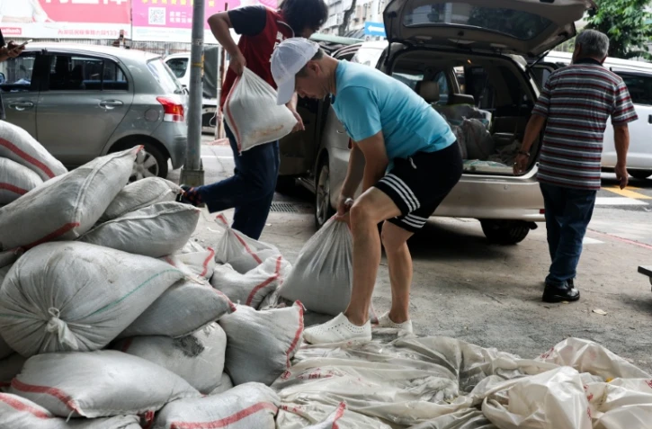 Des habitants installent des sacs de sable pour se protéger du typhon Bavi, le 9 juillet 2026 à Taipei, sur l'île de Taïwan