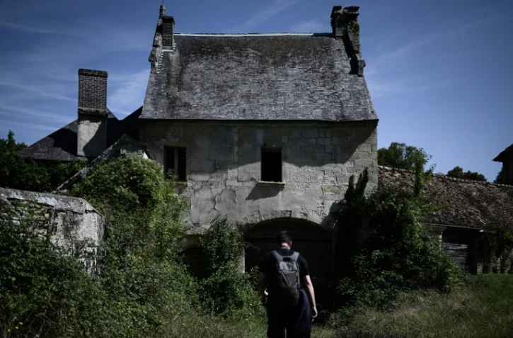 Un adepte de l'urbex, l'exploration urbaine, visite un vieux corps de ferme abandonné, le 22 août 2019 au nord de Paris