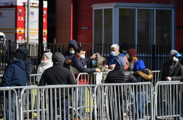 Des New-Yorkais attendent pour se soumettre au test de dépistage du coronavirus à l'hôpital d'Elmhurst, le 26 mars 2020