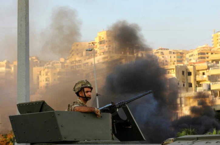 Un soldat libanais est assis dans un véhicule blindé tandis que l'armée se déploie au milieu d'affrontements dans la région de Khalde, au sud de Beyrouth, le 1er août 2021