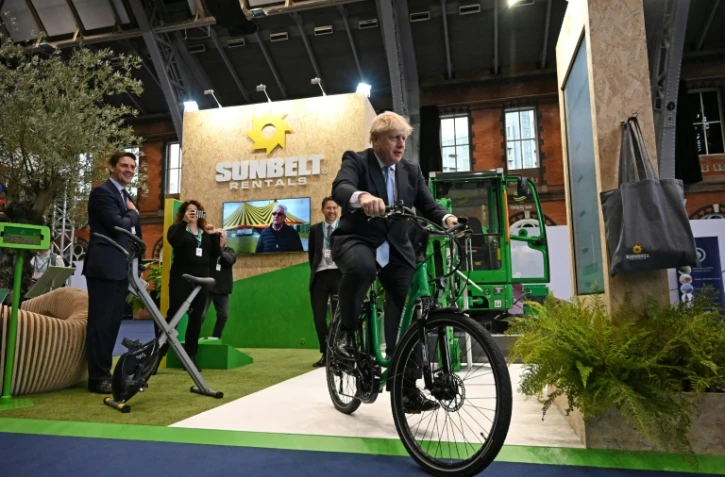 Boris Johnson teste un vélo électrique lors de la conférence annuelle des Conservateurs à  Manchester le 5 octobre 2021