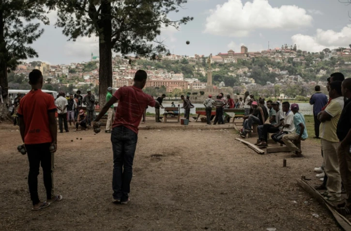 Des boulistes amateurs tirent et pointent sur un terrain de fortune au bord du majestueux lac Anosy, au centre de la capitale malgache