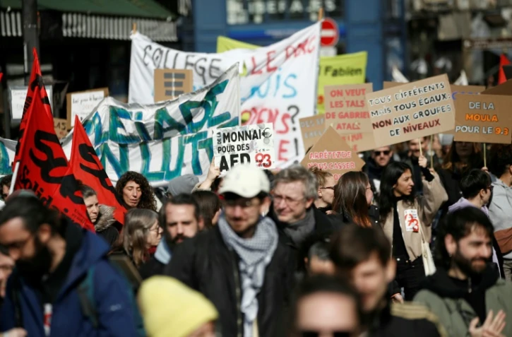 Des manifestants brandissent des pancartes alors qu'ils marchent vers le ministère de l'Éducation nationale, à Paris, le 7 mars 2024