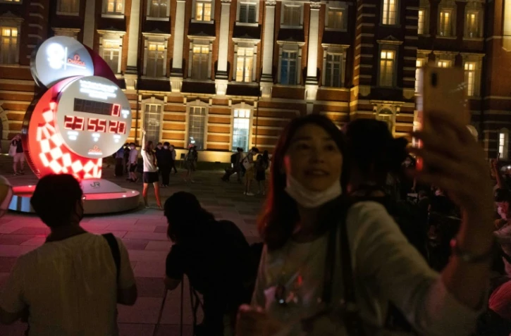 Rassemblement devant l'horloge du compte à rebours, à la veille du coup d'envoi des Jeux olympiques de Tokyo-2020, à Tokyo le 22 juillet 2021