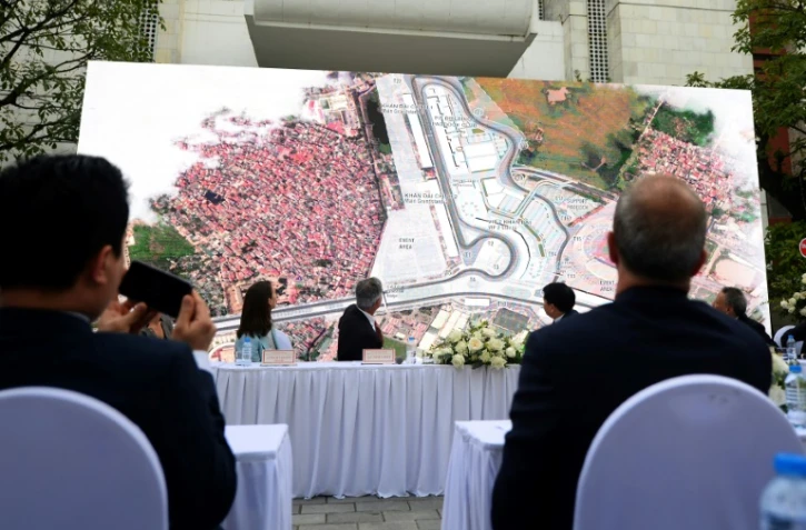 Le patron de la F1, Chase Carey (c) en conférence de presse regarde la carte du circuit qui accueillera le 1er GP de F1 au Vietnam, le 7 novembre 2018 à Hanoi