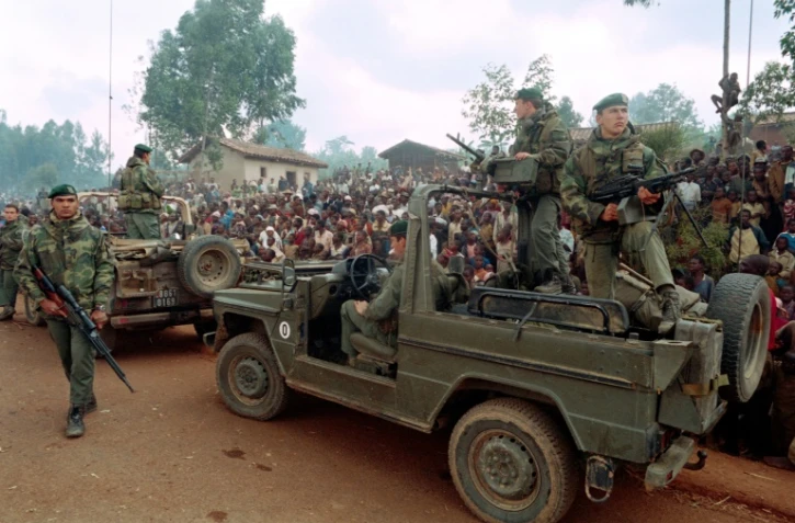 Des Hutus rwandais accueillent des soldats français faisant partie de l'opération militaire Turquoise alors qu'ils traversent un camp de réfugiés, à environ 4 km de Butare, le 3 juillet 1994
