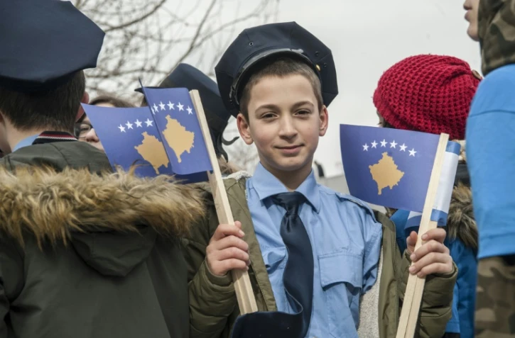 Un jeune Kosovar, déguisé en policier, brandit le drapeau de son pays, le 16 février à Pristina, à la veille des célébrations de l'indépendance.