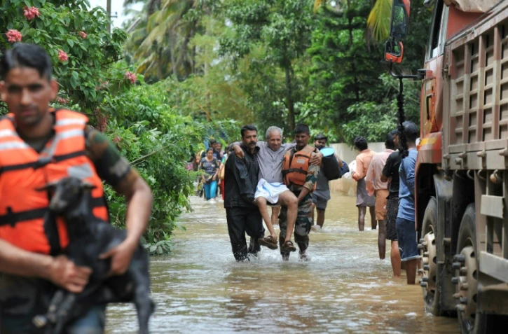 Les secouristes évacuent une victime des inondations dans le village de Mala, au sud de l'Inde, le 19 août 2018