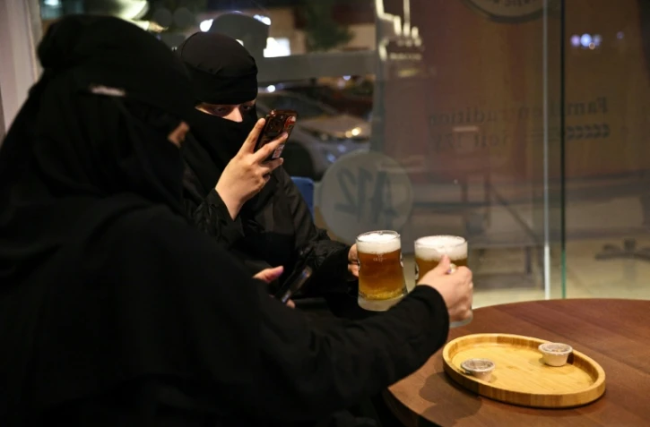 Deux femmes prennent en photo leur bière sans alcool à Ryad, Arabie saoudite, le 24 octobre 2025