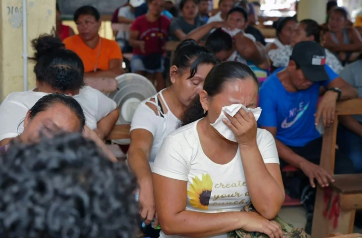 Des proches des victimes de l'incendie d'un dortoir scolaire de Mahdia, au Guyana, pendant une réunion avec le président du pays Irfaan Ali, le 22 mai 2023