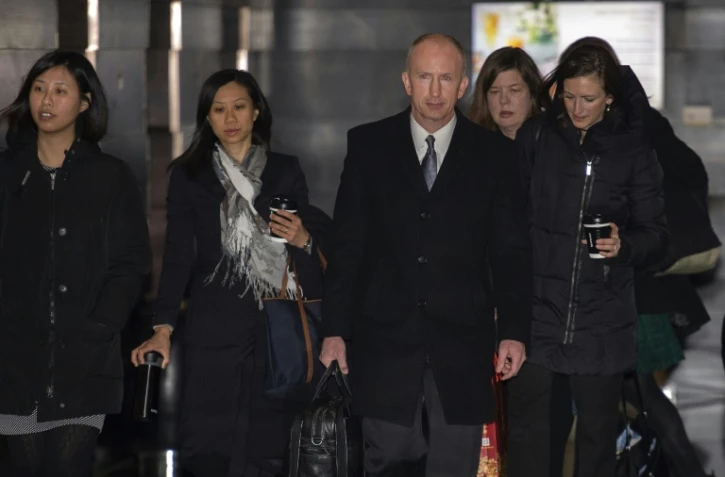 Le représentant adjoint américain au commerce Jeffrey Gerrish (C) et des membres de l'équipe de négociateurs quittent leur hôtel, avant une réunion avec des responsables chinois, à Pékin le 11 février 2019