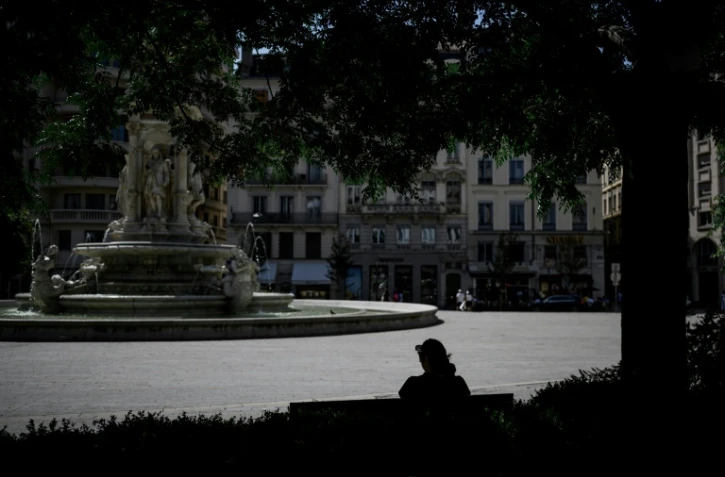 Une personne est assise à l'ombre sur la place des Jacobins, le 25 juin 2025 à Lyon