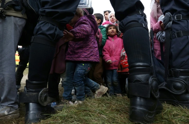 Des enfants parmi les migrants sont encadrés par des policiers slovÚnes, le 22 octobre 2015 prÚs du village de Rigonce en Slovénie