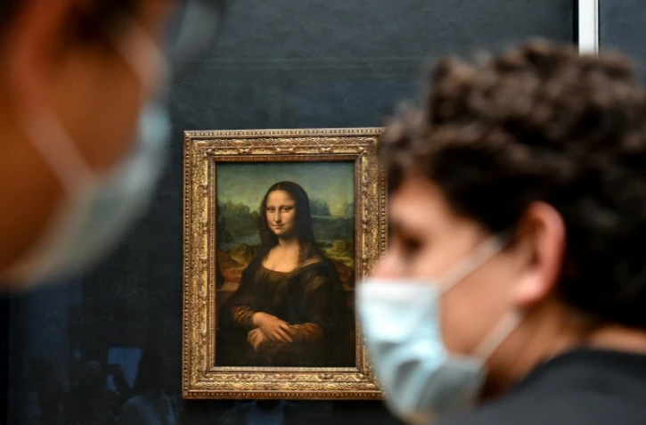 Des visiteurs masqués devant la Joconde au musée du Louvre à Paris