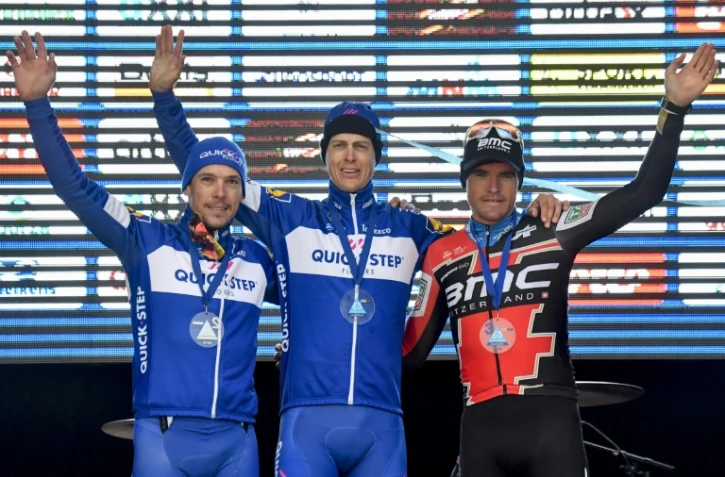 Les Belges Philippe Gilbert (d) et Greg Van Avermaet (g) encadrent le vainqueur néerlandais Niki Terpstra lors de la 61e édition de l'"E3 Prijs Vlaanderen Harelbeke", le 23 mars 2018