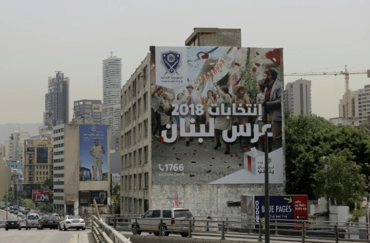 Une banderole géante sur laquelle est écrit "Les élections 2018, les noces du Liban" est déroulée par le ministère de l'Intérieur sur le mur d'un immeuble à Beyrouth avant les législatives du 6 mai, le 2 mai 2018