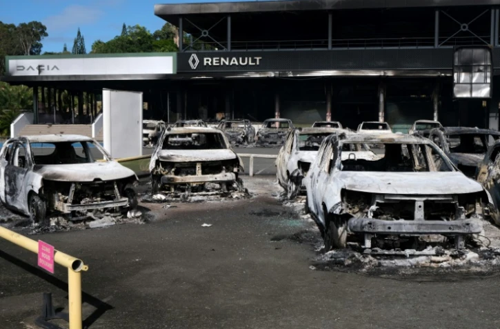 Des voitures incendiées devant un concessionnaire automobile du quartier Magenta à Nouméa, le 14 mai 2024