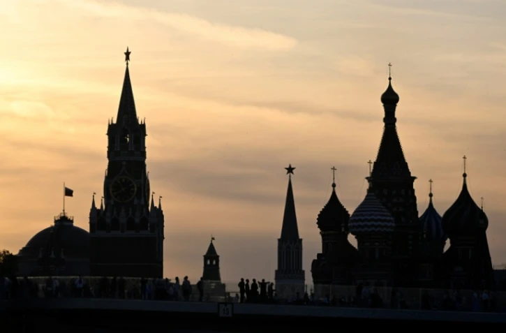 Des promeneurs contemplent la vue du Kremlin depuis un pont du parc Zariadié, le 1er juillet 2023 à Moscou