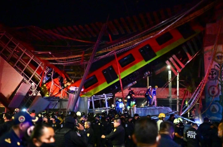 Des équipes de secours sur les lieux de l'effondrement d'un pont du métro aérien au passage d'une rame, le 3 mai 2021 à Mexico