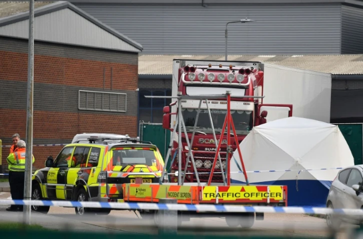 Des policiers britanniques se tiennent près d'un camion charnier dans lequel 39 migrants vietnamiens ont trouvé la mort, le 23 octobre 2019 à Grays (Royaume-Uni)