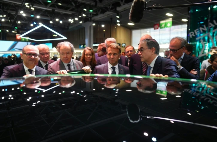 Emmanuel Macron, entouré de Luc Chatel, président de la Plateforme automobile (à gauche), et de François Provost, directeur général du groupe Renault, au Mondial de l’Auto à Paris, le 12 octobre 2026