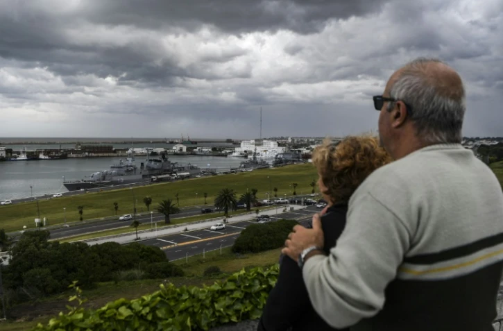 Un couple regarde un bateau militaire à son retour dans le port de Mar del Plata après ses recherches du sous-marin argentin San Juan, le 20 novembre 2017   